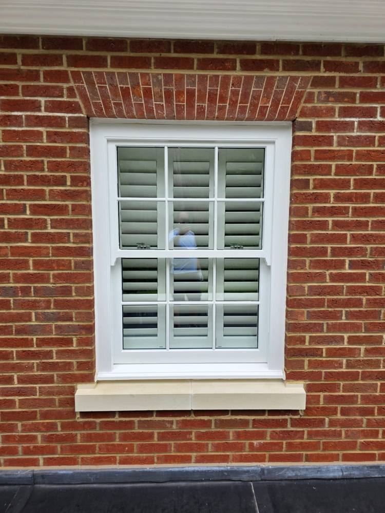 White painted sash window with shutters
