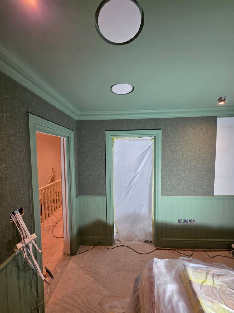 Bedroom painted dark green with panelled walls