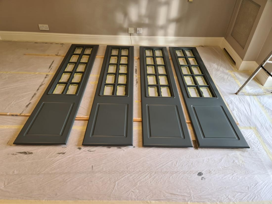 Glazed doors laid out after spraying in dark grey